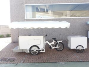 Cargo bike bianca con rimorchietto street food pizza carne